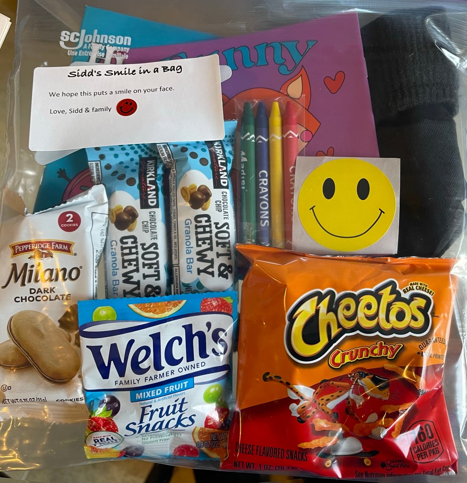 A finished Smile Bag with snacks, crayons, and a note from Sidd and family