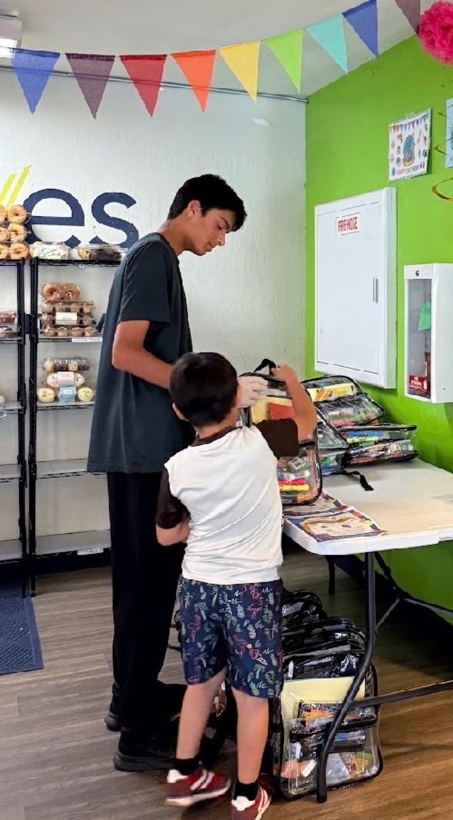 A volunteer handing a packed backpack to a child